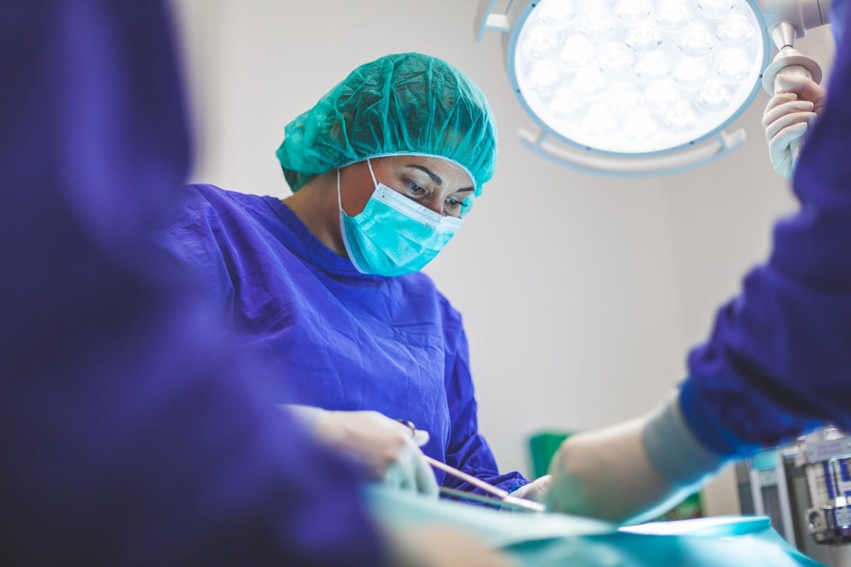 Emergency provider working under bright treatment lighting, reflecting the focused wound care chemical burns require
