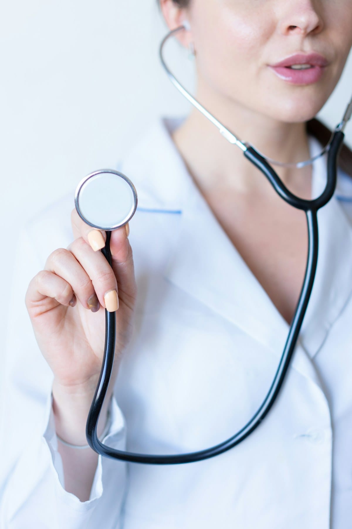ER physician holding a stethoscope, ready to perform an abdominal exam for severe stomach pain